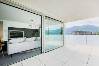 Seuil bas et caniveau au pied d'une porte-fenêtre Seuil bas en aluminium au pied d'une porte-fenêtre, avec caniveau à grille devant la terrasse